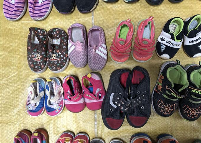 La seconda mano dei bambini copre le scarpe/scarpe utilizzate variopinte di sport per l'estate
